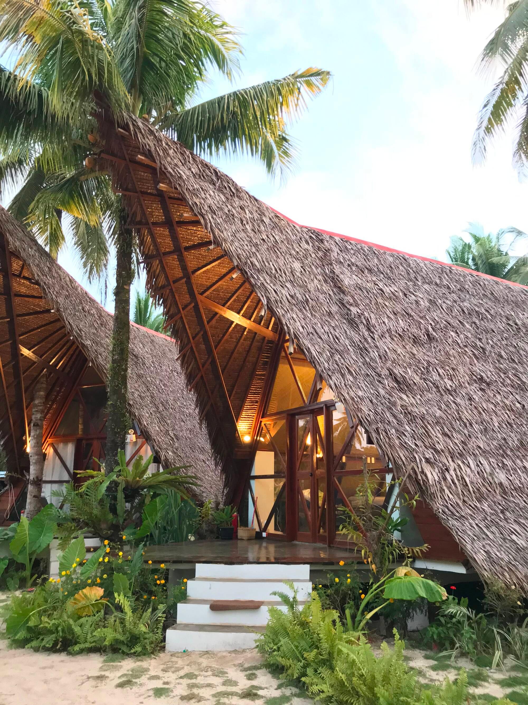 Thatched A-frame villas among palms at Dahun Villas