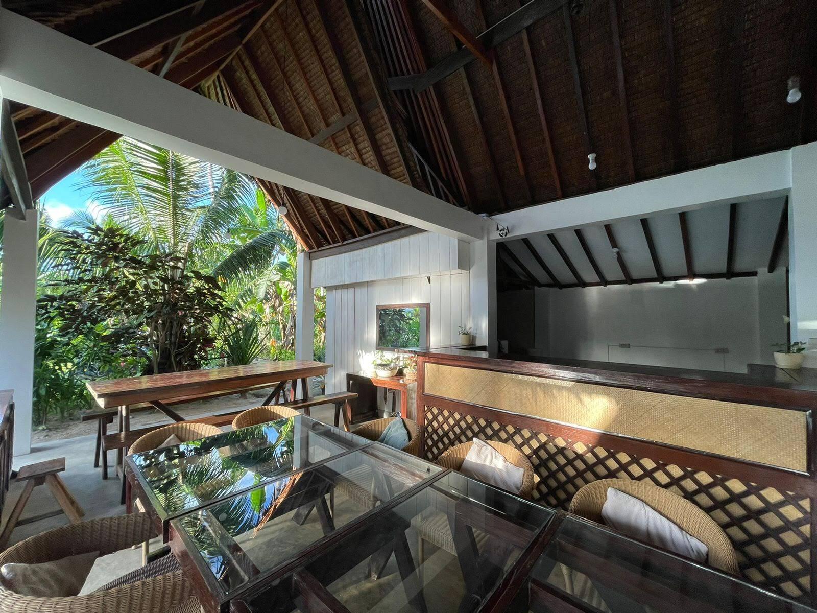 Shared lounge and kitchen area under a wooden roof